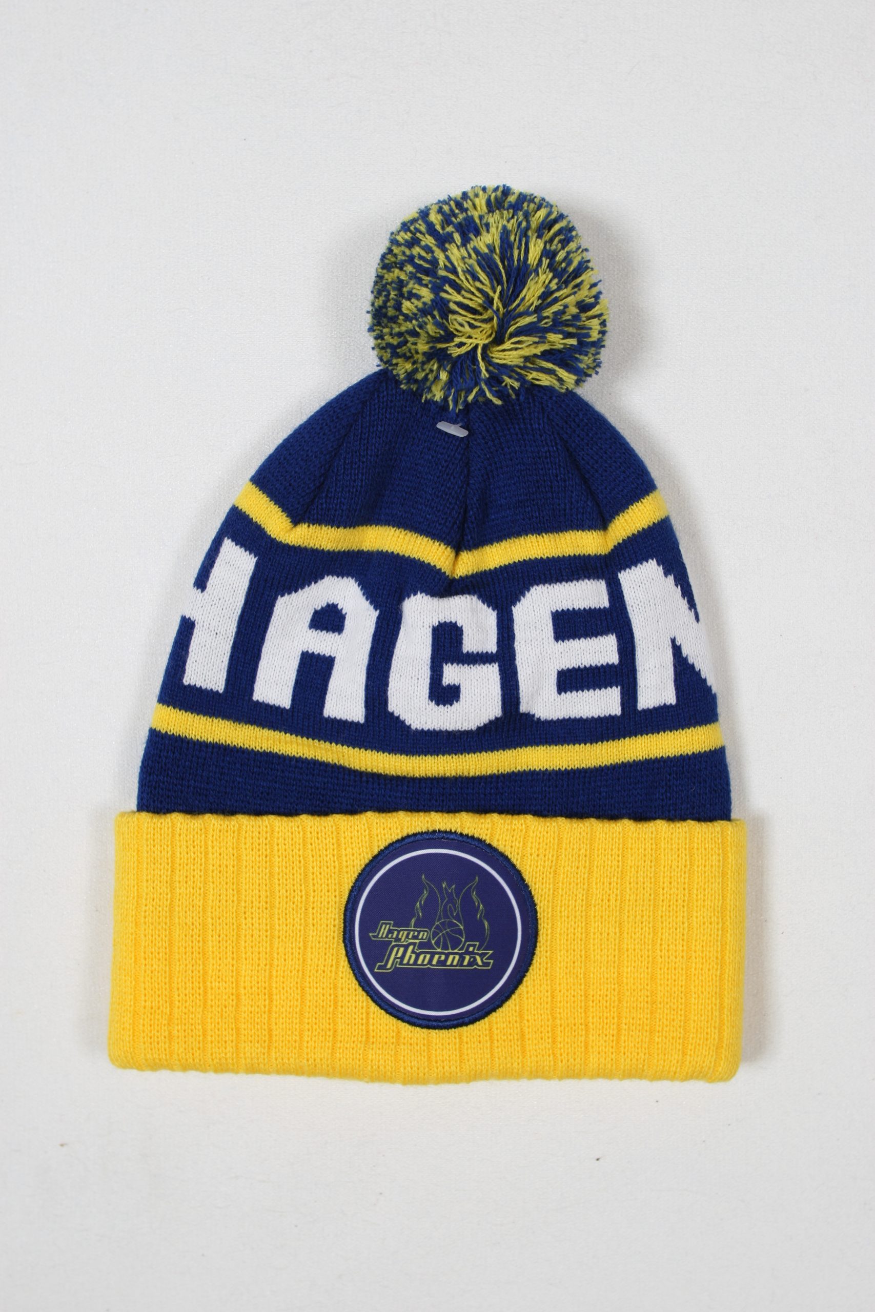 Blau-gelbe Mütze mit einem Pompon und der Aufschrift 'HAGEN' auf der Vorderseite.