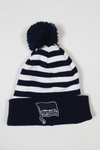 Gestreifte Mütze in Blau und Weiß mit einem Pompon und dem Hertha BSC Logo auf dem Umschlag.