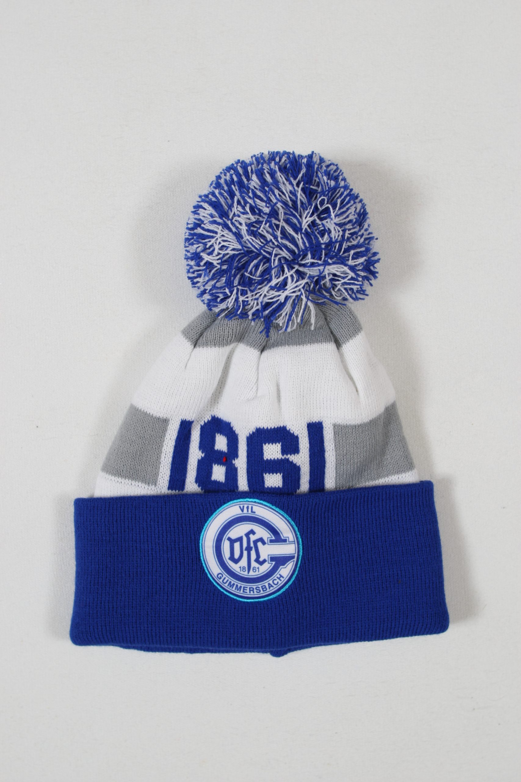 Blau-weiße Mütze mit einem grauen Streifen und einem großen Bommel oben.