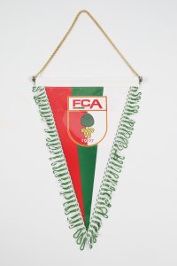 Wimpel des FCA mit grün-rotem Design und Logo, verziert mit Fransen.