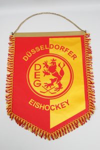 Wimpel der Düsseldorfer EG mit rotem und gelbem Design und Löwenmotiv.