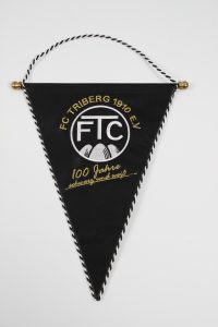 Schwarzer Wimpel des FC Triberg 1910 e.V. mit goldener Schrift und Logo.