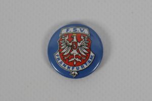 Runder blauer Button mit dem Wappen des FSV Frankfurt, der einen doppelköpfigen Adler zeigt.