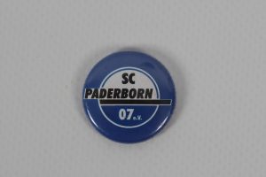 Runder Anstecker mit dem Logo des SC Paderborn 07 in Blau und Weiß.