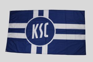 Flagge des KSC in Blau mit weißen Streifen und dem KSC-Logo in der Mitte.