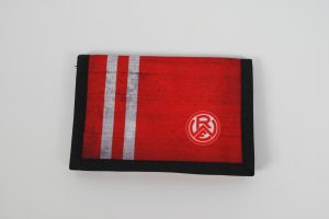 Rote Geldbörse mit schwarzen und weißen Streifen sowie einem Logo auf der Vorderseite.