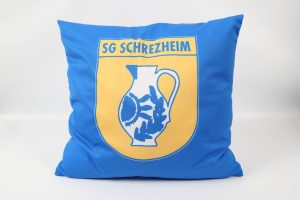 Blaues Kissen mit dem Logo der SG Schrezheim, das eine Kanne und Symbole zeigt.