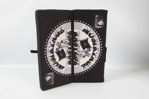 Schwarzes Klappkissen mit einem weißen Musiktage-Logo und Sternen auf der Oberfläche.