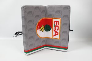 Sitzkissen mit dem Logo des FCA in rot, grün und weiß auf grauem Hintergrund.