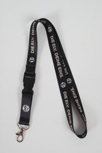 Schlüsselband in Schwarz mit dem Aufdruck 'DIE EINE: DEINE EINS.' und einem Karabinerhaken.