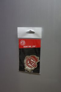 Magnet mit RWE Logo in einer transparenten Verpackung auf grauem Hintergrund.