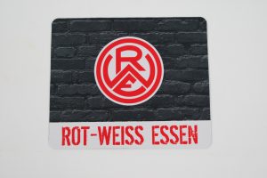 Mauspad mit dem Logo von Rot-Weiss Essen auf einer schwarzen Backsteinmauer.