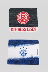 Zwei Mauspads mit den Logos von Rot-Weiss Essen und UFC Gummersbach auf einer grauen Oberfläche.