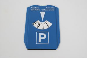 Blaue Parkscheibe mit Uhrzeitangaben für die Ankunftszeit in mehreren Sprachen.