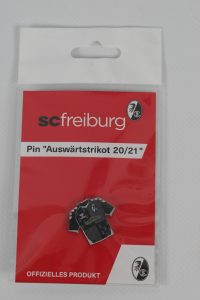 Pin des SC Freiburg mit dem Design des Auswärtstrikots der Saison 20/21 in einer Verpackung.