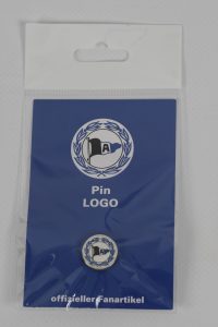 Ein Pin mit einem Logo, verpackt in einer blauen Blisterverpackung mit Aufschrift.