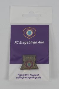 Anstecknadel mit dem Logo des FC Erzgebirge Aue in einer Verpackung.