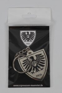 Metallischer Schlüsselanhänger in Form eines Wappens mit einem Adler und der Jahreszahl 1906.