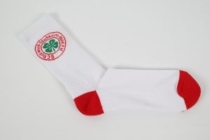 Weiße Sportsocken mit rotem Bündchen und einem grünen Logo auf der Seite.