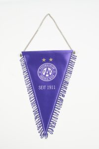 Lila Wimpel des Fußballclubs Austria Wien mit Fransen und Vereinslogo.