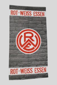 Frottierhandtuch mit bedruckter Bordüre in Rot und Grau, mit großem ROT-WEISS ESSEN Schriftzug und Vereinslogo im markanten Brick-Look.