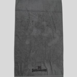 Ein Frottierhandtuch mit bedruckter Bordüre zeigt das Logo SG Dettenheim auf grauem Stoff und passt zum Produkt Handtücher bedruckt (50 x 100 cm).